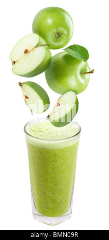 Slices of apple falling into a glass of fresh juice Stock Photo