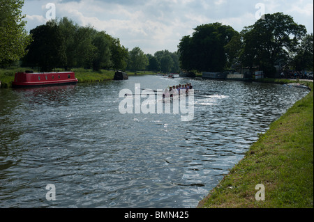 A racing shell passes a narrow boat on the River Cam during Cambridge University's May Bumps, 2010 Stock Photo