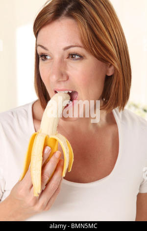 WOMAN EATING A BANANA Stock Photo