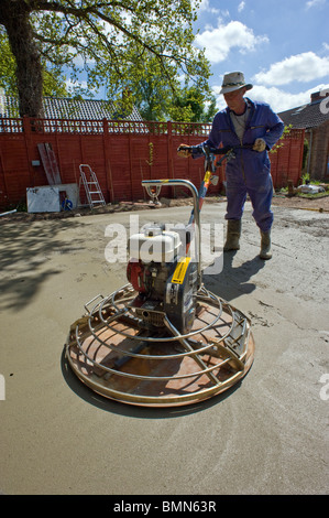 man levelling concrete base with power float Stock Photo