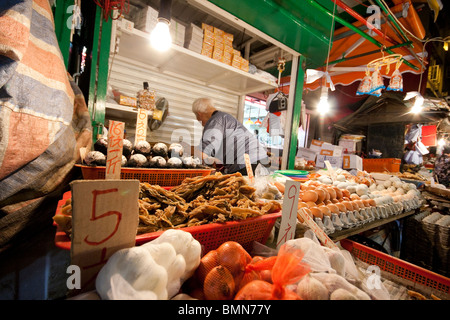 An older man selling meat, fish and eggs in market in Wan Chai, Hong Kong Stock Photo