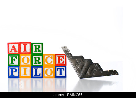 Colorful children's blocks spelling AIR FORCE PILOT with a toy B2 Stealth Bomber Stock Photo