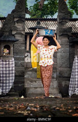 On the Hindu holy day of Kunningan, women in the village of Pemuteran, Bali bring offerings to the local temple. Stock Photo