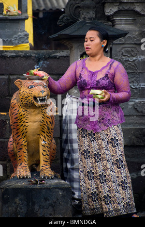 On the Hindu holy day of Kunningan, women in the village of Pemuteran, Bali bring offerings to the local temple. Stock Photo