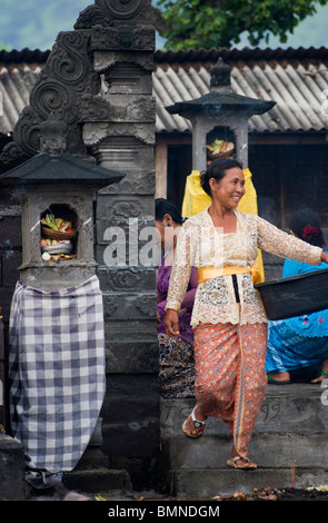 On the Hindu holy day of Kunningan, women in the village of Pemuteran, Bali bring offerings to the local temple. Stock Photo