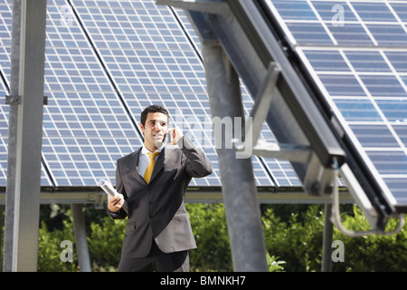 male engineer talking on mobile phone in solar power station Stock Photo