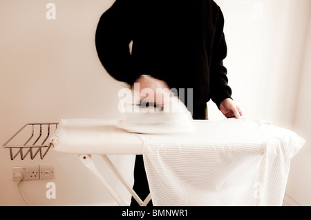 A man Ironing a shirt.  ( with motion blur ) Stock Photo