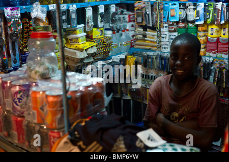 A young boy keeping a small hardware store at a night market in Tofo, Mozambique, Africa Stock Photo