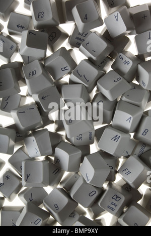 A photograph from above of old computer keyboard keys scattered randomly. Stock Photo