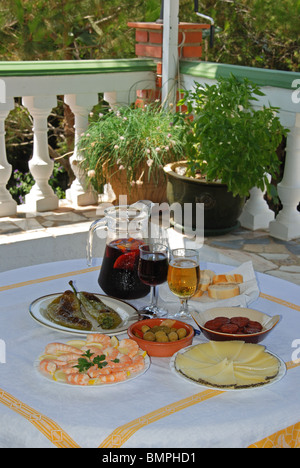 Tapas. Clockwise from top. Sangria, beer, bread, chorizo, Manchego, prawns, peppers, olives in centre, Andalucia, Spain, Europe. Stock Photo