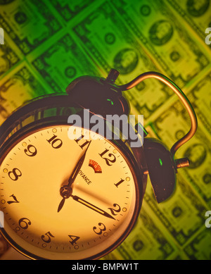 Time is money concept.  antique style Alarm clock on pile of 100 dollar bills. Timely timers timetable Stock Photo