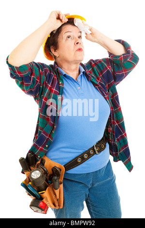 Female construction worker wipes sweat from her forehead. Isolated on white. Stock Photo
