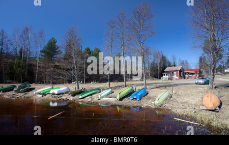 Finnish small boat harbor at countryside at early Spring . Upturned rowboats and skiffs  / dinghy dinghies, Finland Stock Photo