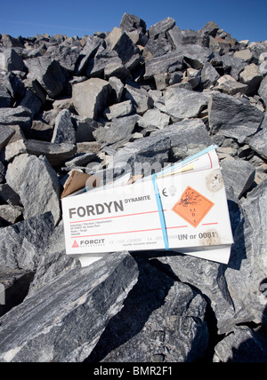 Empty dynamite box on exploded rocks . Bedrock is exploded to smaller pieces that are processed to gravel for construction and roads , Finland Stock Photo