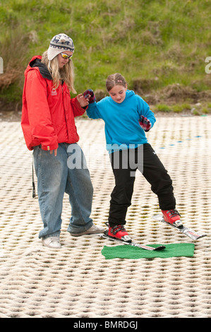 A girl learning to ski on the dry ski slope at The Urdd Centre, Llangrannog, Ceredigion, West Wales UK Stock Photo