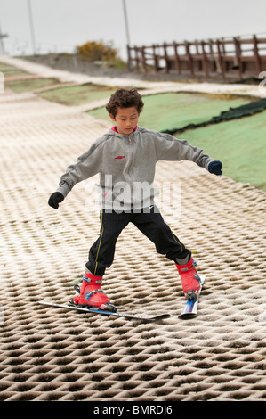 A young boy learning to ski on the dry ski slope at The Urdd Centre, Llangrannog, Ceredigion, West Wales UK Stock Photo