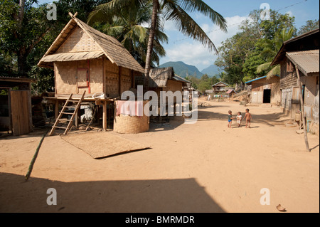 Small tribal children play near rattan & stilt houses in a tribal village in Vong Xai province Northern Laos Stock Photo