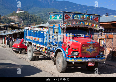 Decorated Tata truck in Jakar main street with the dzong in the background, Jakar Bhutan Stock Photo