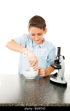 School boy in science class using a mortar and pestle. White background.  Stock Photo