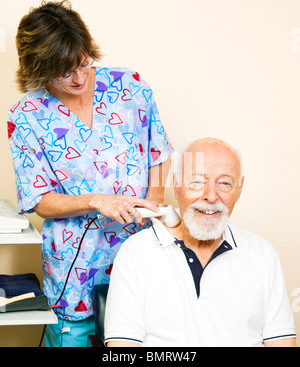 Senior man getting ultrasound therapy for his neck pain.  Stock Photo
