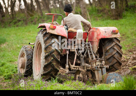 Senior farmer using an old tractor to plow his land Stock Photo