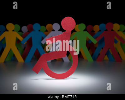 A disable paper figure stands under the spotlight on his wheelchair. Stock Photo