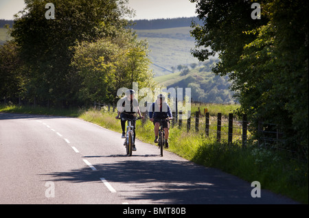 UK, England, Derbyshire, Edale, cyclists in Hope Valley cycling on empty road Stock Photo