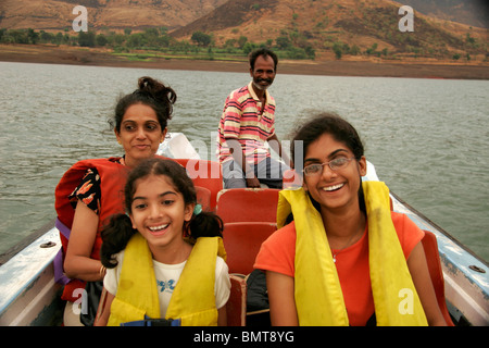 South Asian Indian mother with daughters wearing life-jackets enjoying motor boat ride at Dhom dam ; Wai ; Maharashtra ; India Stock Photo