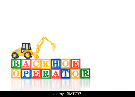 Colorful children's blocks spelling BACKHOE OPERATOR with a model backhoe Stock Photo