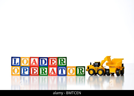 Colorful children's blocks spelling LOADER OPERATOR with a model loader earth moving machine loading a dump truck Stock Photo