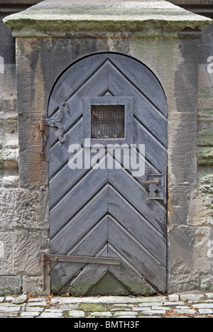 Old church door with a window at level of eyes. Stock Photo