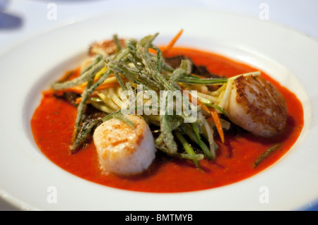 Pan-seared sea scallops on a crispy potato pancake, filled with Gulf shrimp, crab and crawfish tails,at a restaurant in Lafayette, Louisiana, USA. Stock Photo