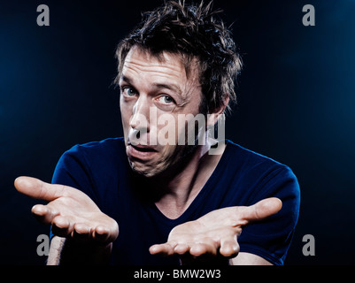 studio portrait on black background of a funny expressive caucasian man hesitant puckering Stock Photo