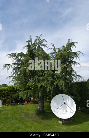 large motorized sky satellite dish in garden Stock Photo