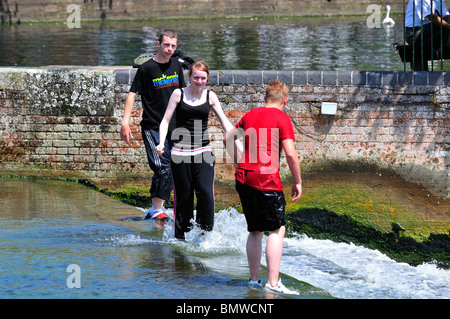 Teenagers playing on a weir on river Ooze, Bedford Stock Photo