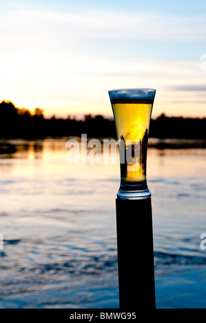 a refreshing beer in front of a scandinavian sunset Stock Photo