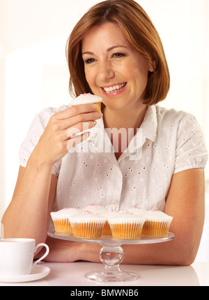 WOMAN EATING A CUPCAKE Stock Photo