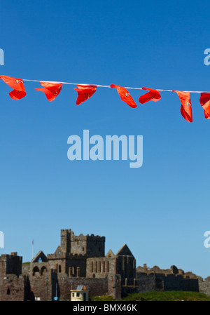 Peel Castle in Isle of Man with red flags on the foreground Stock Photo