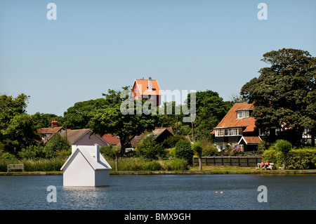 A replica of the iconic House in the Clouds floating in Thorpeness Meare in Suffolk in the UK. Stock Photo