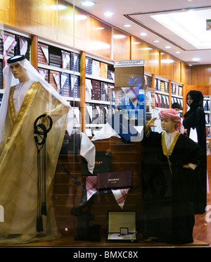 Woman shopper in a menswear store selling Gulf Arab national dress at the Abu Dhabi Mall, Abu Dhabi Stock Photo