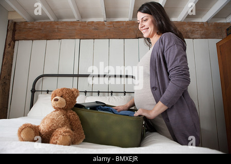 Expectant mother packing suitcase Stock Photo