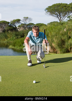 Man playing golf, on putting green Stock Photo