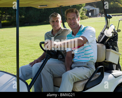 Two mature men in golf cart on golf course Stock Photo