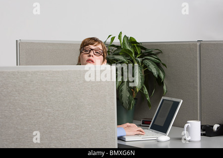 Businesswoman peeking over screen Stock Photo