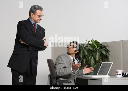 Boss watching over businessman Stock Photo