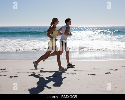 Young couple jogging on beach Stock Photo