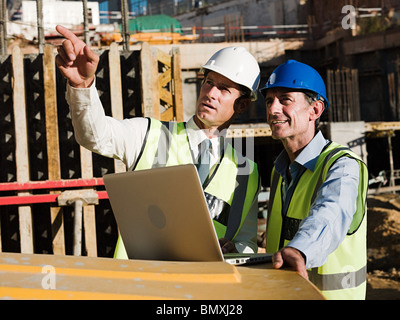 Mature men with laptop on construction site Stock Photo
