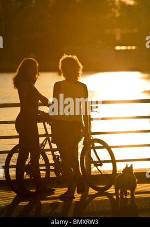 Two young women talking on the Allier Lake right bank, at Vichy. Jeunes femmes discutant sur la rive droite du lac d’Allier Stock Photo