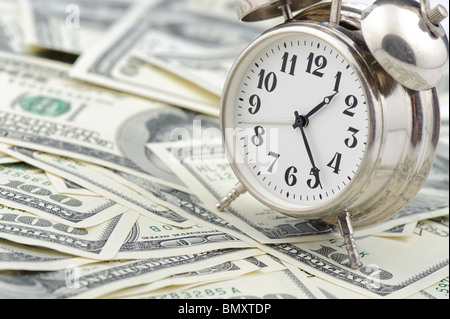 Time - money. Business concept. Analog hours on a heap of paper dollars Stock Photo