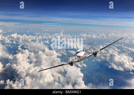 Airplane flying high above the clouds Stock Photo